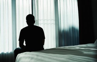 Άντρας κάθεται μόνος του στο κρεβάτι Άντρας κάθεται μόνος του στο κρεβάτι