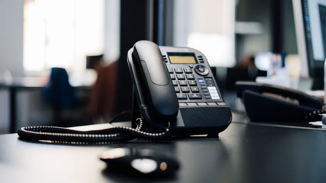 phone-number-security-us-fcc Τηλεφωνική συσκευή σε γραφείο, σύμβολο για την ασφάλεια των αριθμών και των φωνητικών δικτύων